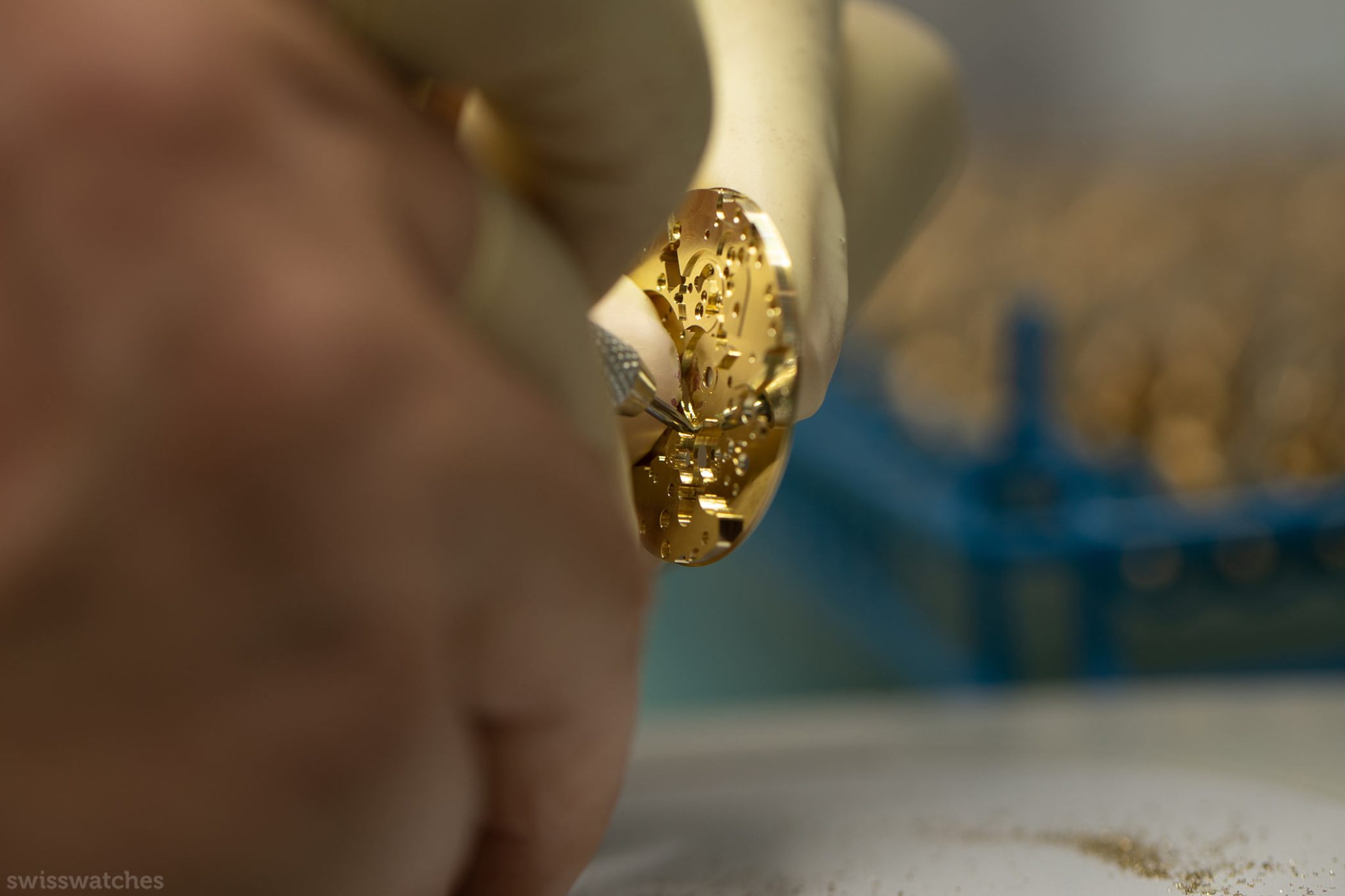 Two hands removing the dust of a gold dial