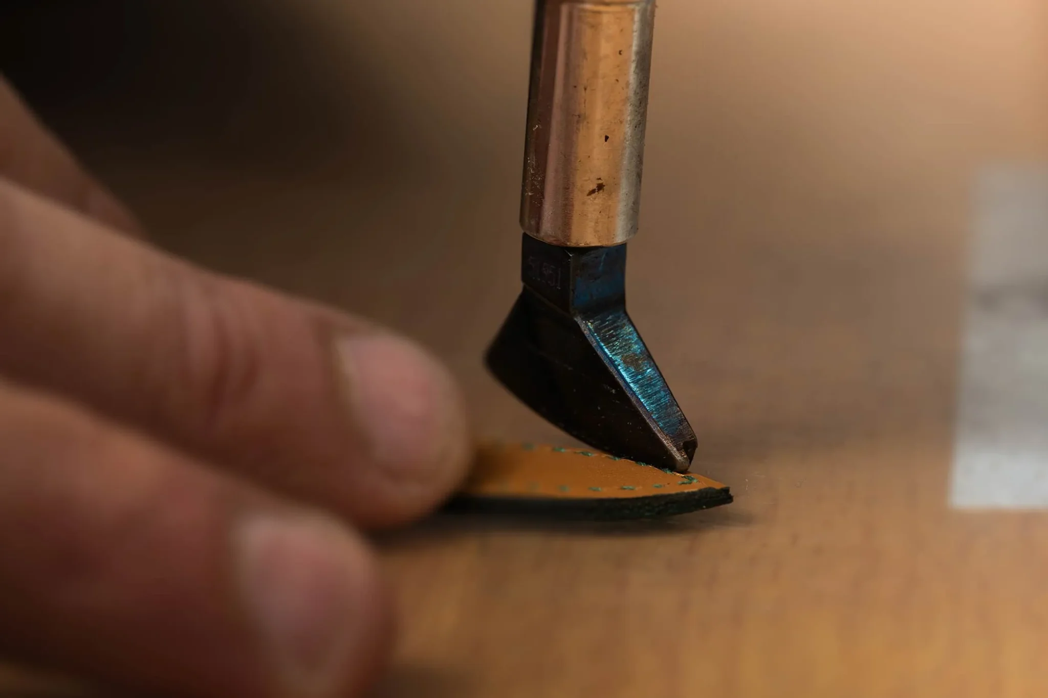 Craftsman sealing the edges of a Hermès watch strap, ensuring durability and a flawless finish in luxury watchmaking
