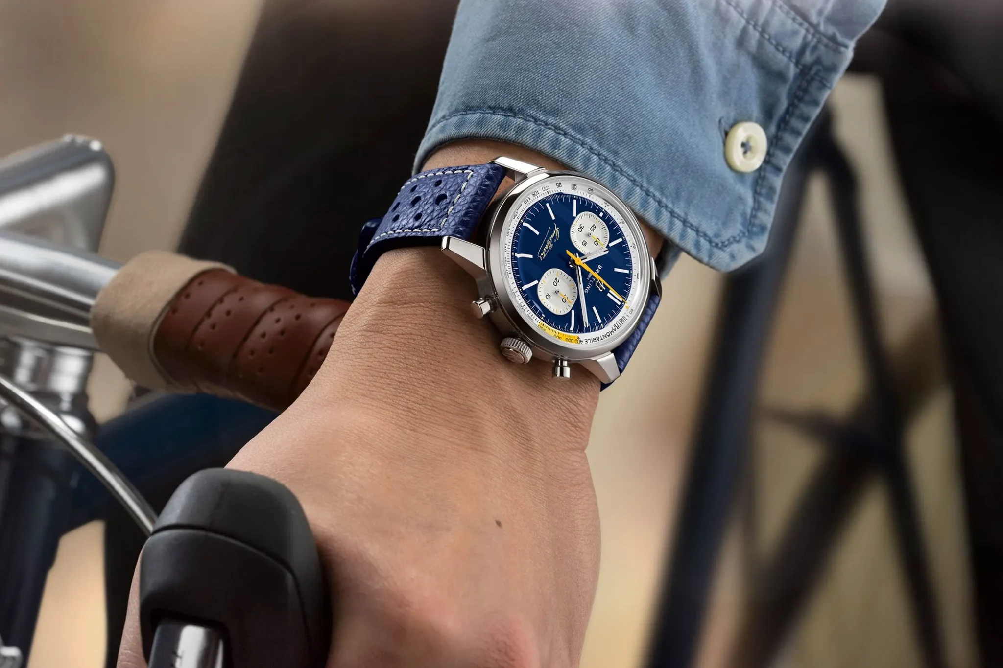 Wristshot of the Breitling Top Time B01 Gino Bartali in blue with the hand on a bike handlebar.