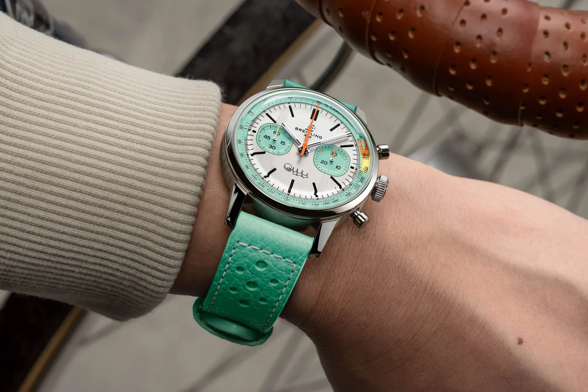 Wristshot of the Breitling Top Time B01 Fausto Coppi in blue with the hand on a bike handlebar.