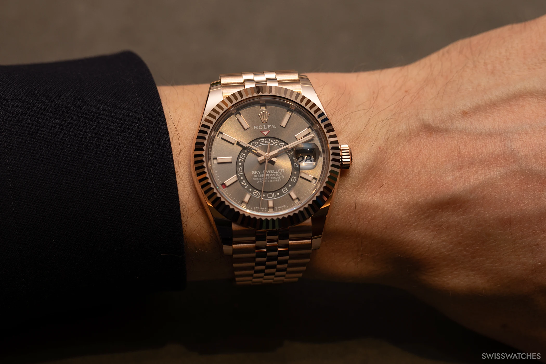The Rolex Oyster Perpetual Sky-Dweller is shown on the wrist.