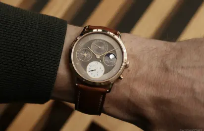 Hermès Slim d’Hermès Perpetual Calendar in rose gold on the wrist with brown leather strap and perpetual calendar displays.