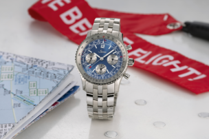 The Sinn 903 Ti II Jubiläum chronograph with blue dial, silver subdials, tachymeter and slide-rule scales, shown from the front on a multi-link stainless steel bracelet.