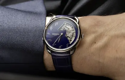 The Hermès Arceau Minute Repeater in white gold with a violet dial is shown from the front on the wrist.