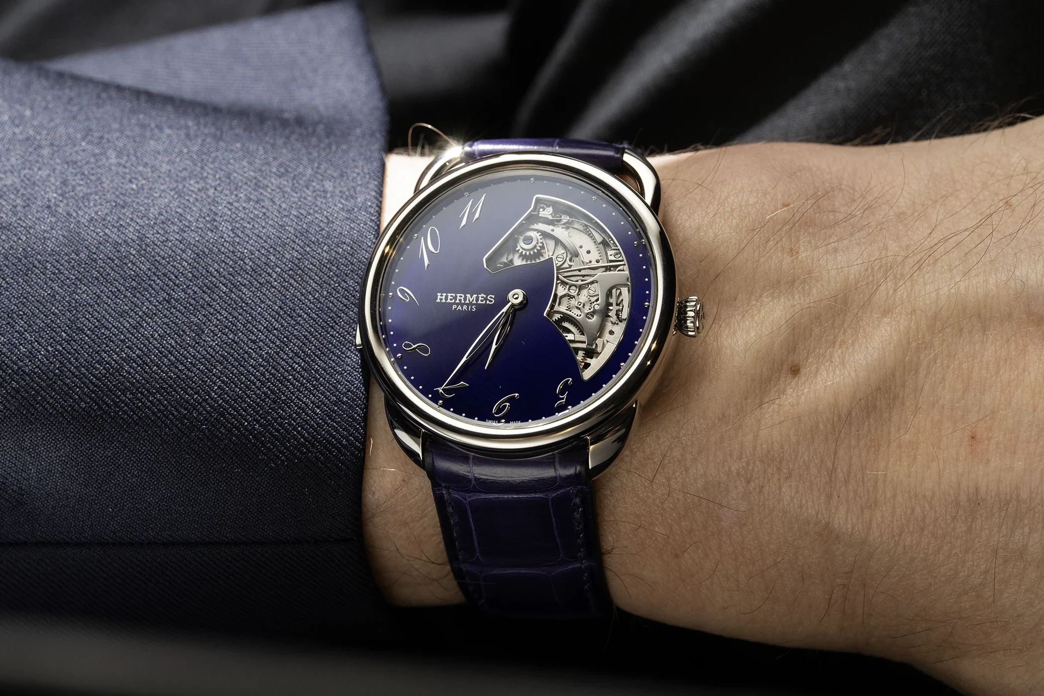 The Hermès Arceau Minute Repeater in white gold with a violet dial is shown from the front on the wrist.
