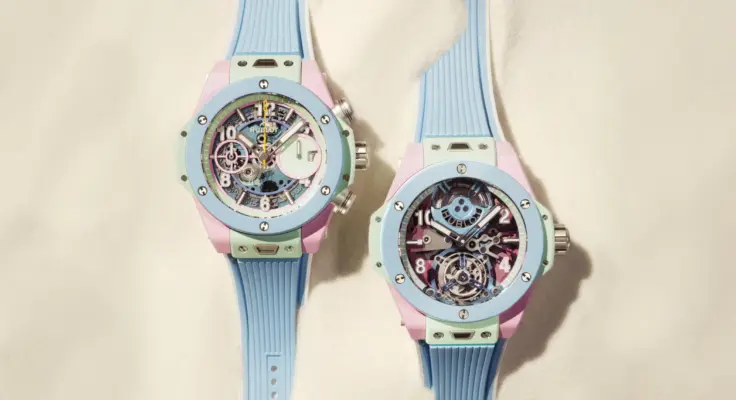 The Big Bang Summer Multi-Colored Ceramic 42 mm and Big Bang Summer Multi-Colored Ceramic 44 mm are lying in the sand; the straps are partially covered.
