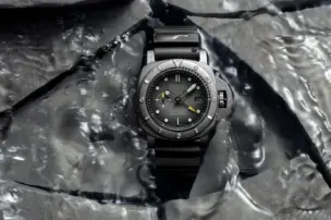 Panerai Submersible GMT Navy SEALs Afniotech Experience Edition PAM01089 on a water-covered surface of broken stone slabs