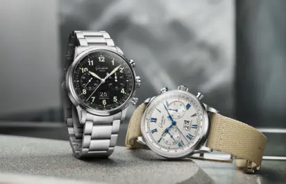 A Glashütte Original Senator Chronograph with a fabric strap and a version with a metal strap are on display together.