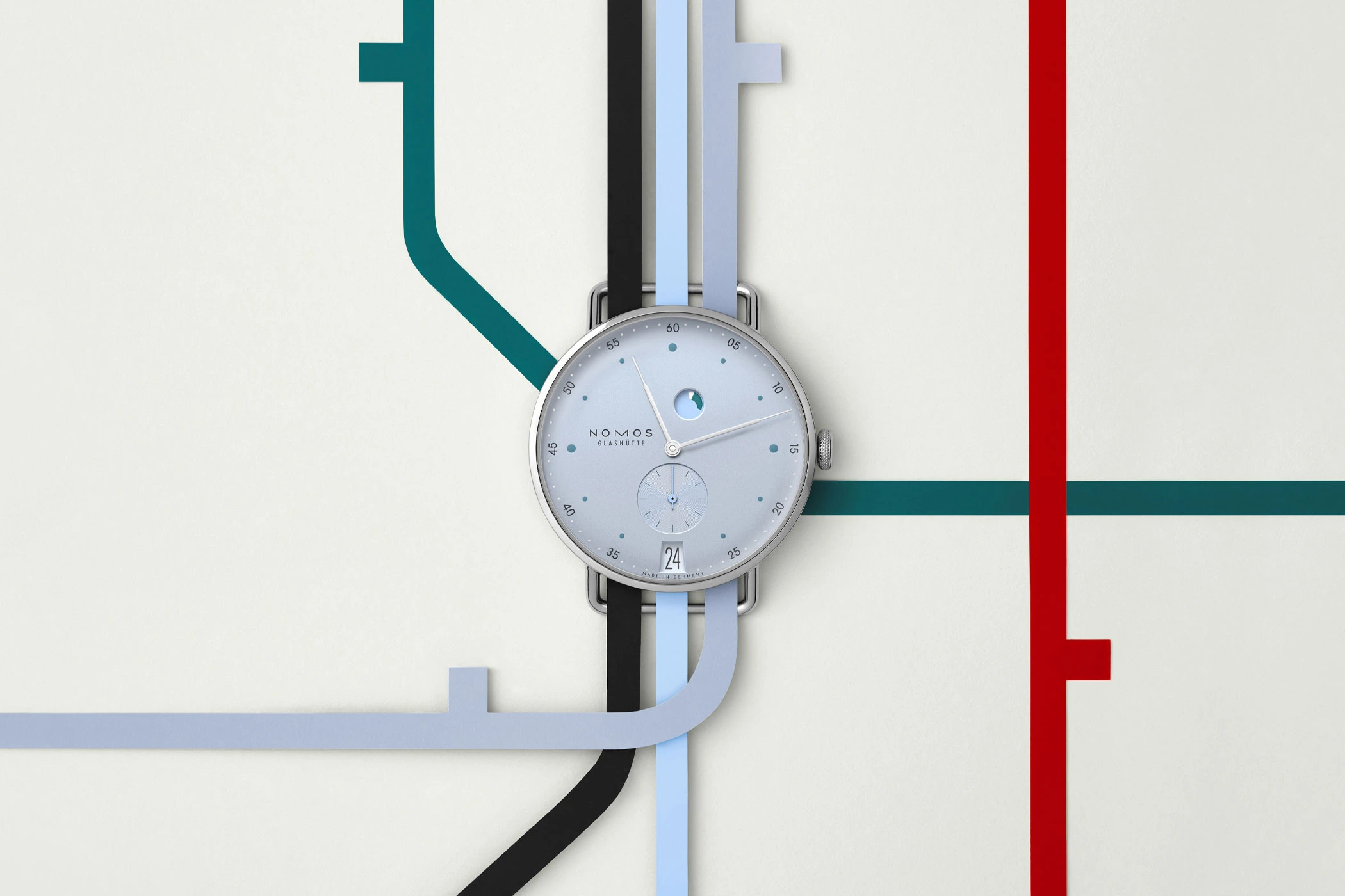 The watch head of the Nomos Glashütte Metro Date Power Reserve Ice, shown against a stylized metro map.