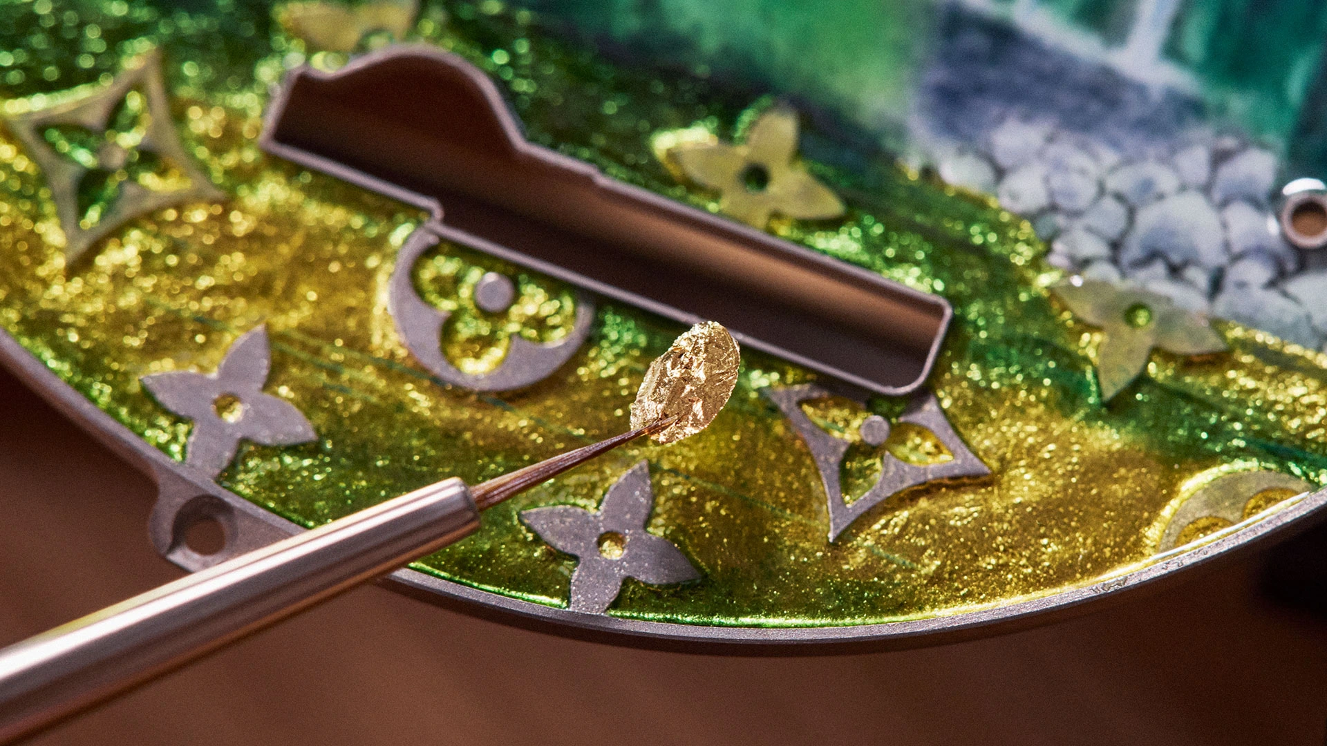 Detail of the paillonné enamelling technique on the Louis Vuitton Escale en Amazonie pocket watch with finely inlaid gold foils